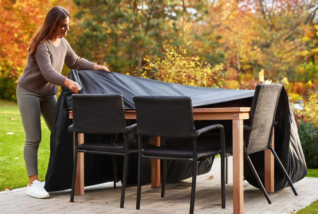 Lady Putting Cover on Patio Furniture in Autumn