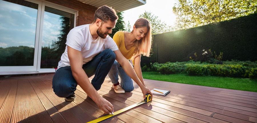 Couple measuring the size of outdoor decking area